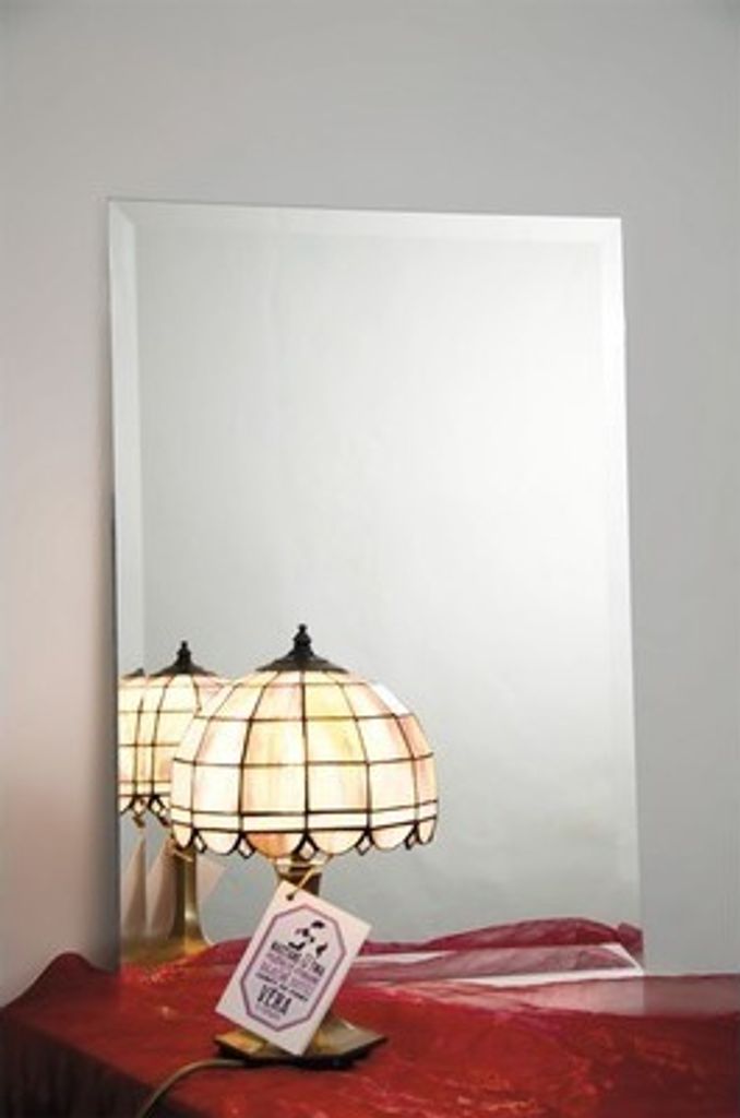 A mirror reflecting two lamps and a small tag.