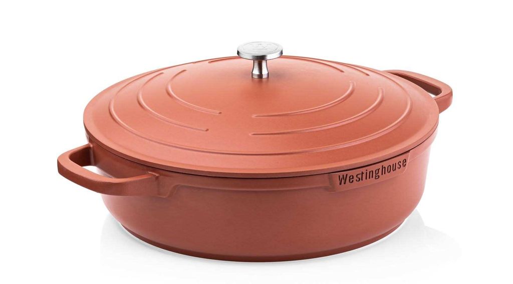 A red cast iron pot with a lid and silver knob, shown from a side angle on a white background.