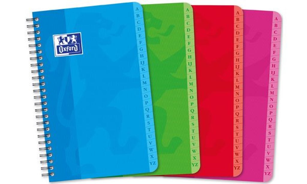 A row of four spiral-bound notebooks with alphabetical tabs.