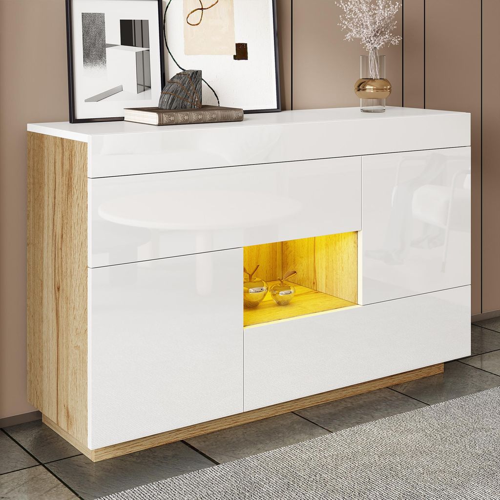 A modern sideboard with a high-gloss white finish and wood grain accents, displayed in a room setting with artwork on the wall and a vase on top.