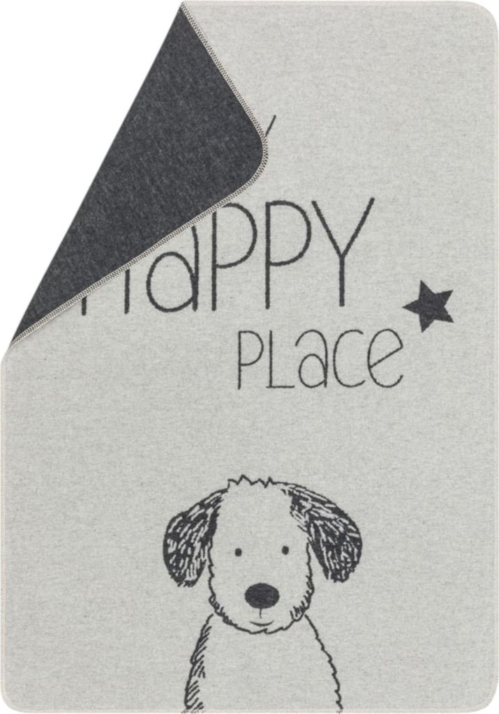 A close-up view of a dog blanket with text and a drawing of a dog.