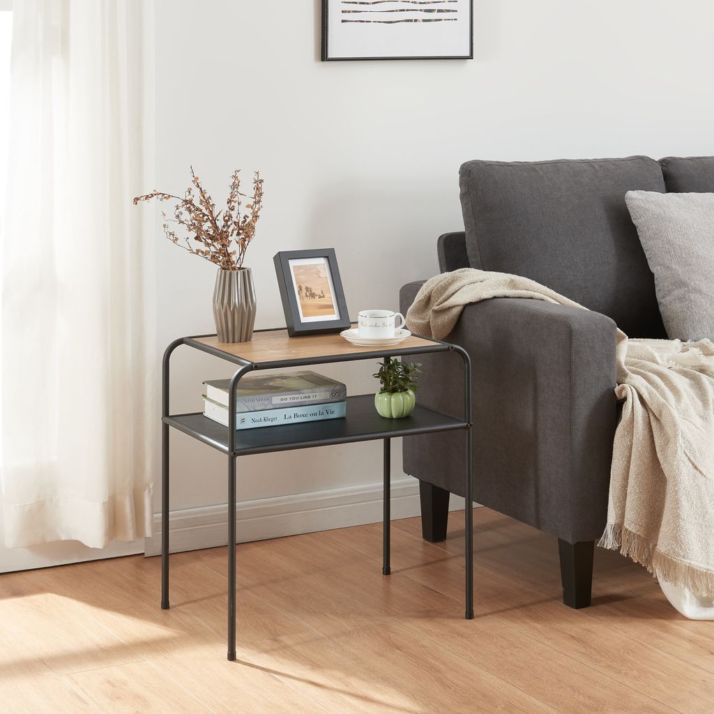 A small side table with decorative items and books next to a sofa.