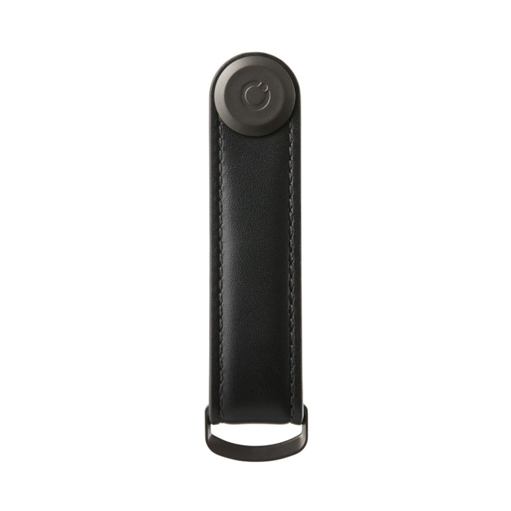 A black leather key organizer with a dark gray circular logo on top and a metal loop at the bottom, isolated on a white background.