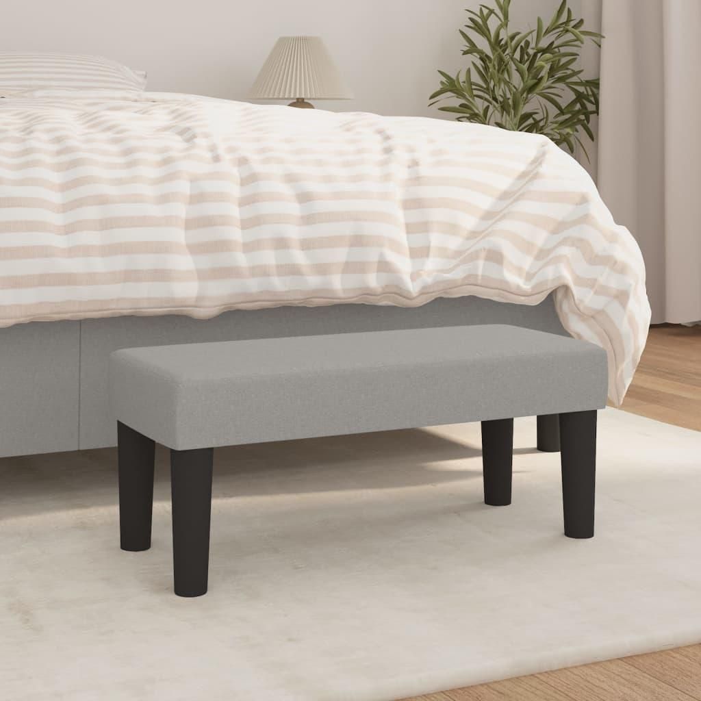 A bench in front of a bed in a bedroom.