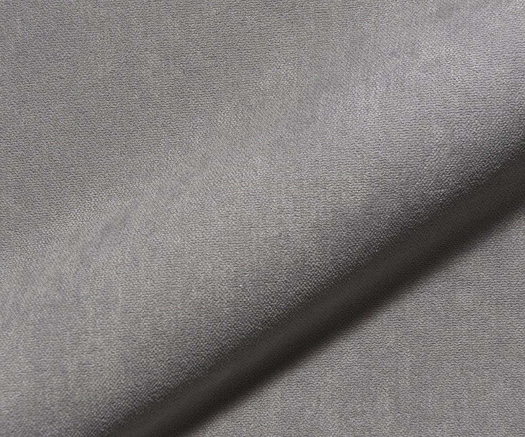 A close-up, angled view of a gray fabric surface, likely a boxspring frame.