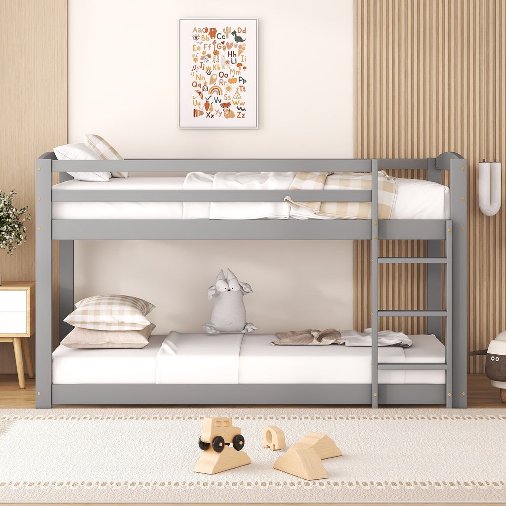 A gray bunk bed with white bedding and pillows, set in a child's room with a colorful alphabet poster on the wall.