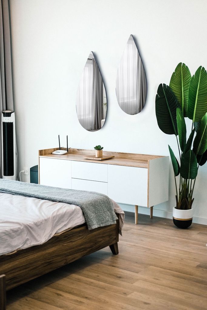 Ein tropfenförmiger Spiegel mit minimalistischem Design und einer schwarzen Staubschutzplatte auf der Rückseite