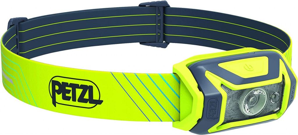 A Petzl TIKKA CORE headlamp with a yellow and blue headband is shown against a white background.