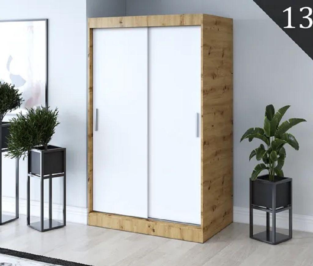 A sliding door wardrobe with white doors and a wood-grain frame, placed in a room with potted plants.
