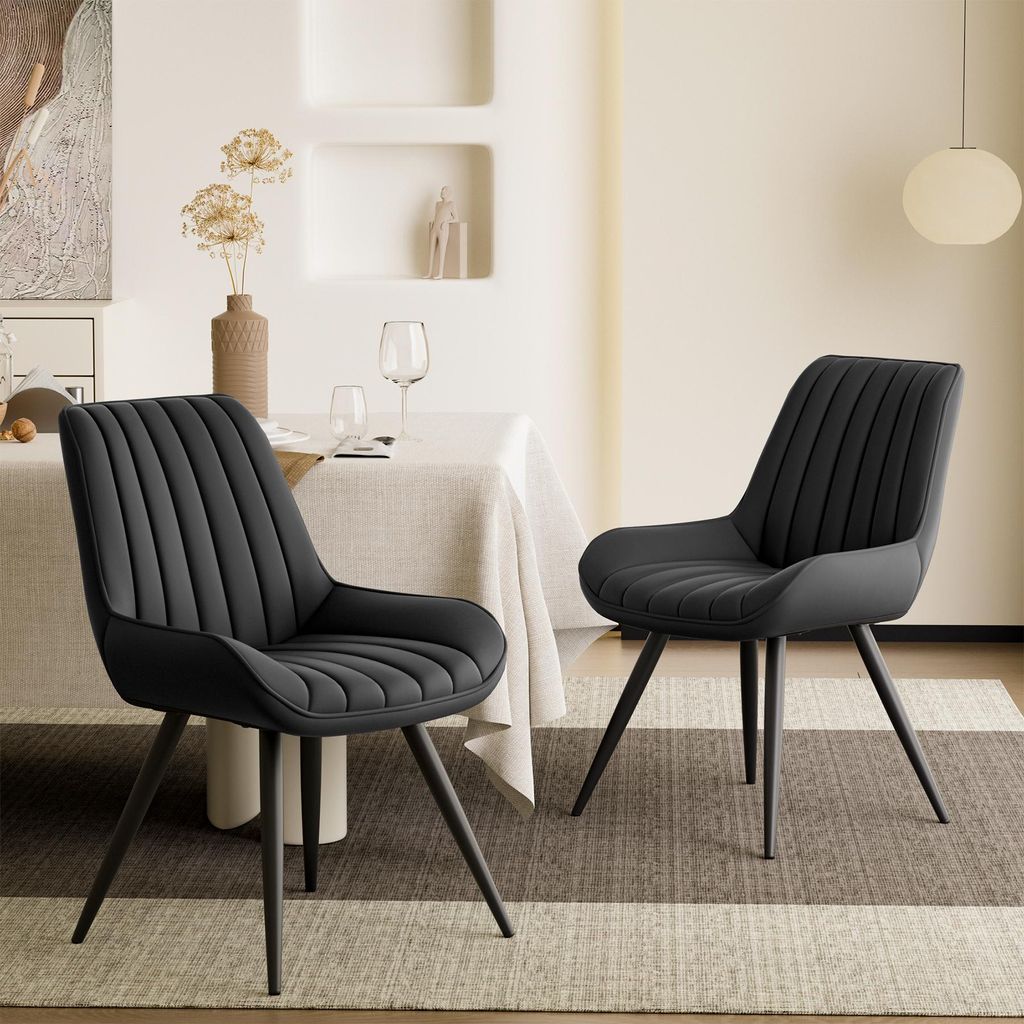 Two black dining chairs are placed around a dining table in a well-lit room.