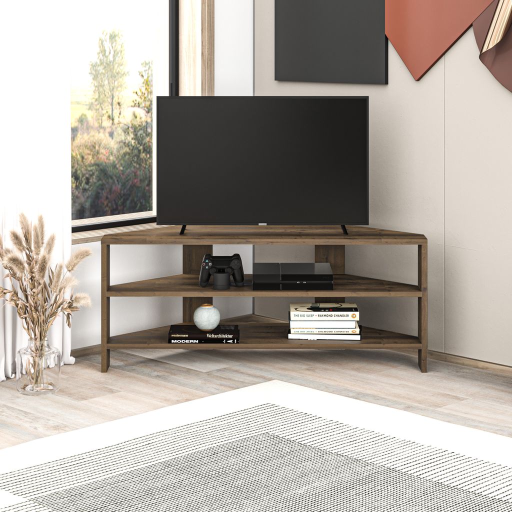 A modern corner TV stand with a television, game console, and books.