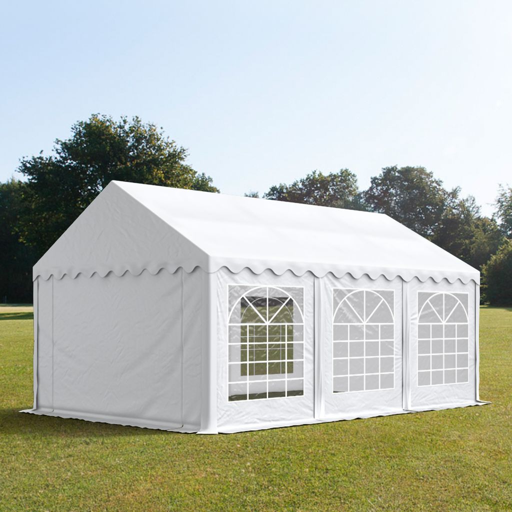 A white party tent is set up on a grassy lawn with trees in the background.