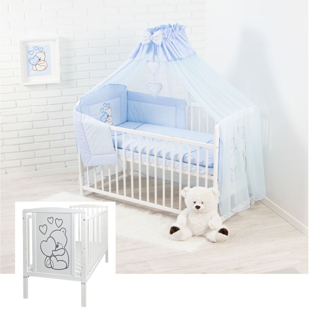 A baby crib set with bedding and a teddy bear.