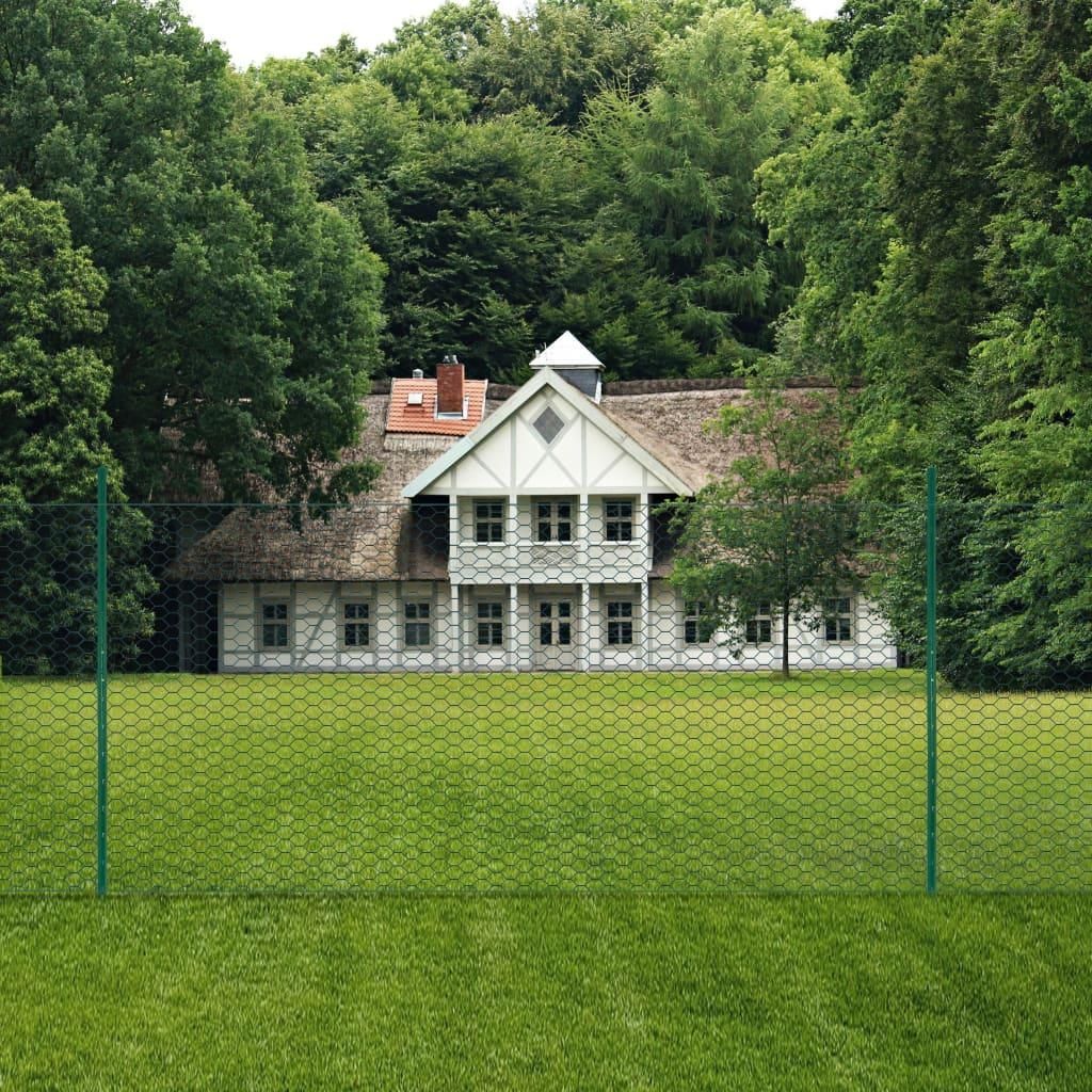 A green wire mesh fence in the foreground with a white house and trees in the background.