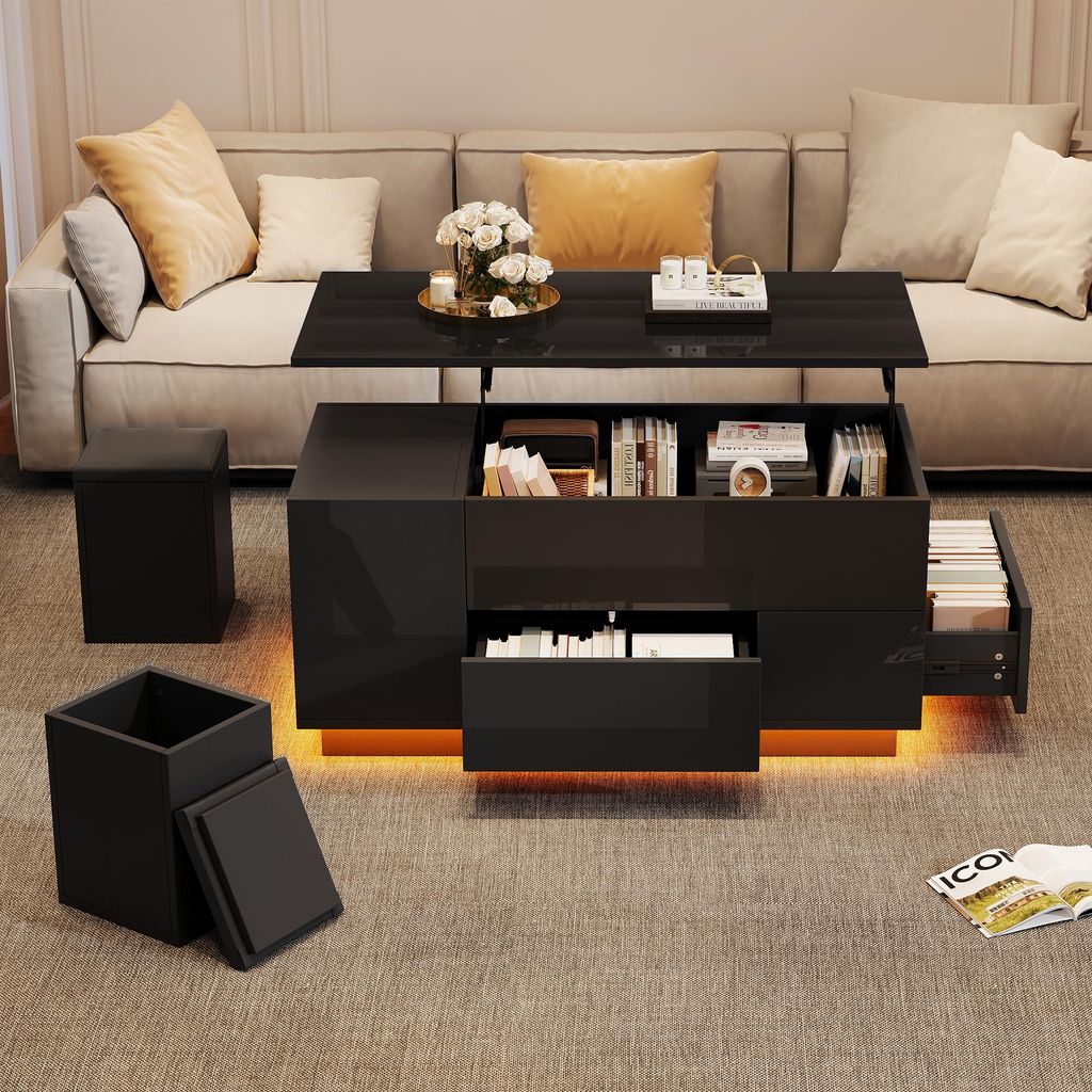 A modern living room scene featuring a black lift-top coffee table with storage, two black stools, and a sofa in the background.