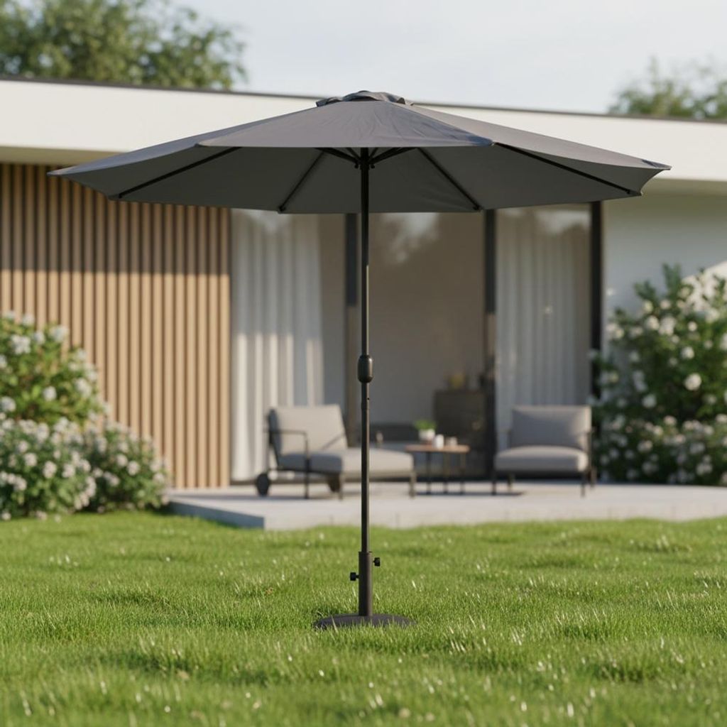 A gray patio umbrella is set up on a green lawn in front of a modern house with outdoor seating.