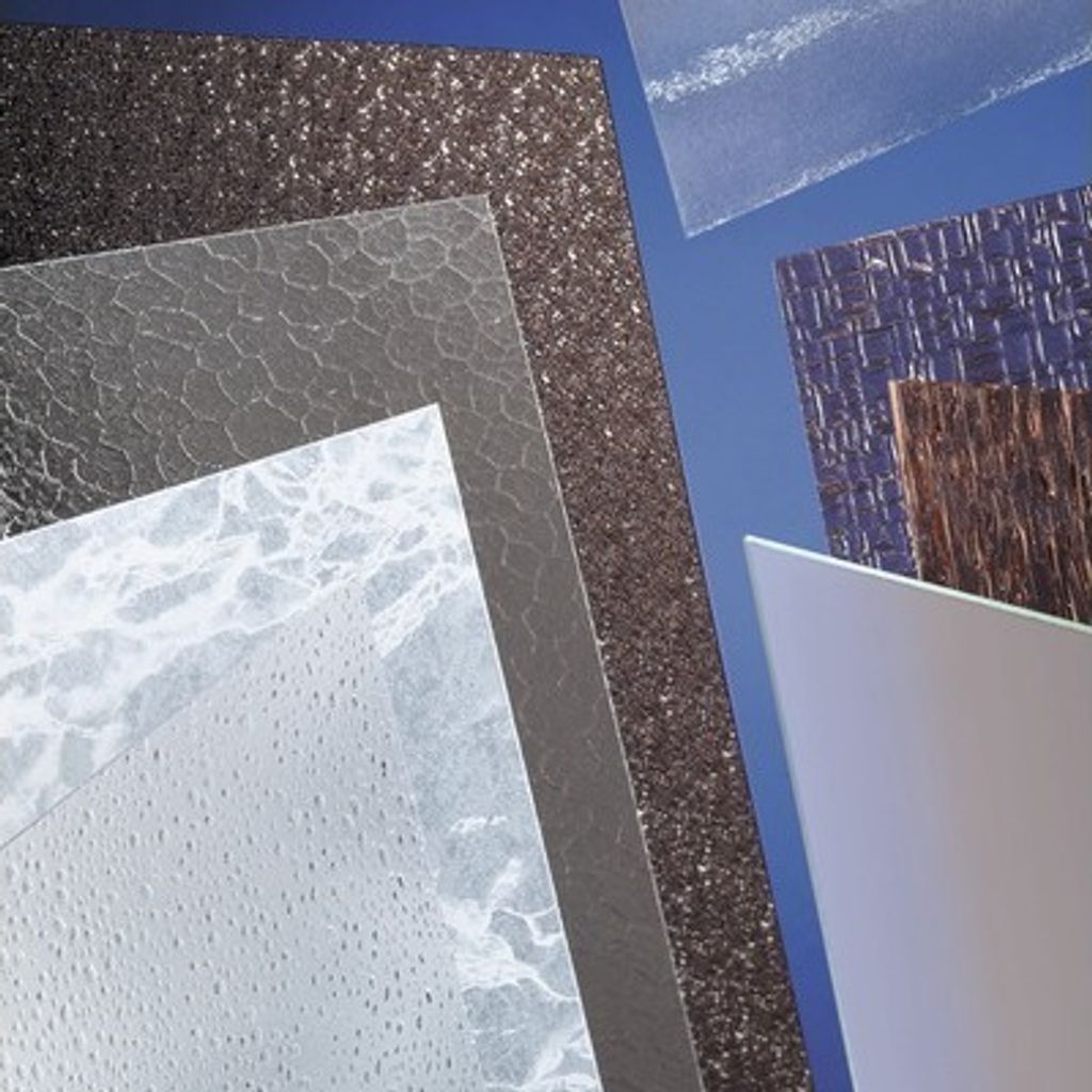 A collection of different textured plastic sheets arranged diagonally against a blue background.