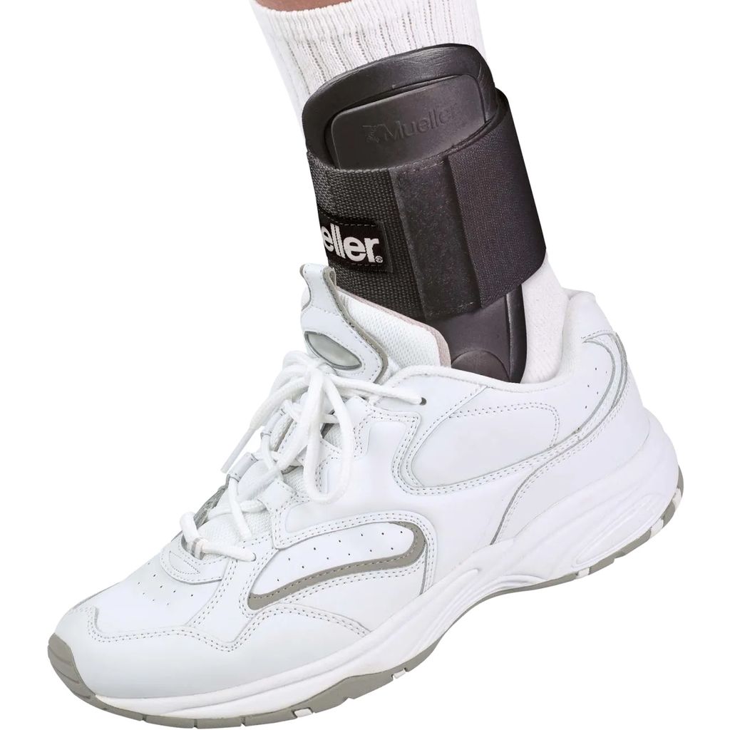 A close-up shot of a white athletic shoe with a black ankle brace on the wearer's foot.