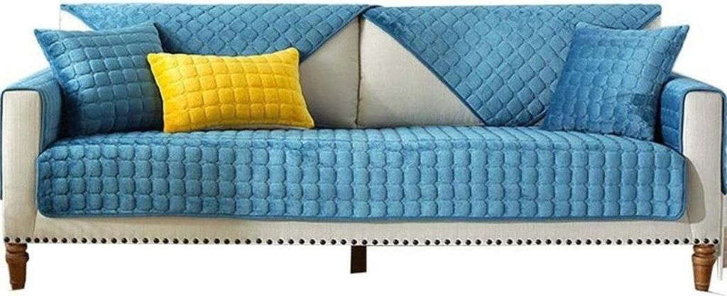 Blauer gesteppter Samt-Sofabezug-Set mit passenden Kissen und einem gelben Akzentkissen auf einem weißen Sofa