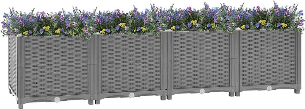 A row of four grey modular raised garden beds filled with purple and yellow flowers.
