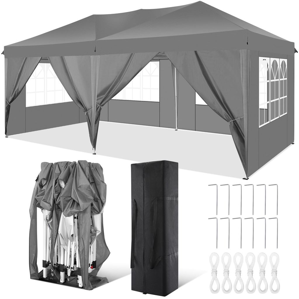 A gray pop-up canopy tent is shown fully assembled, with its sides and windows visible. Below the tent are its folded components, a black carrying bag, and metal stakes with rope loops.