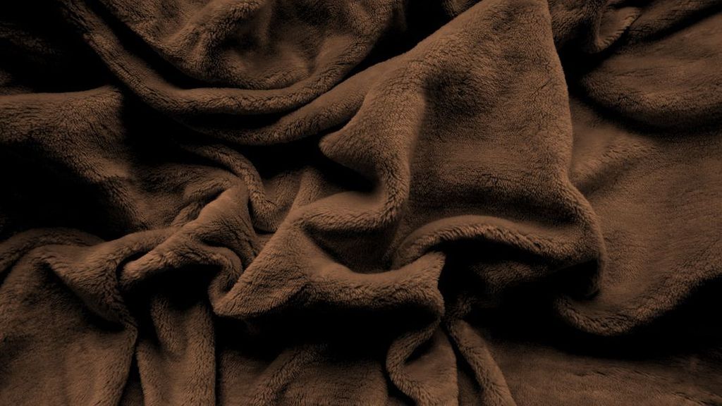 A close-up view of a crumpled dark brown microplush fabric.