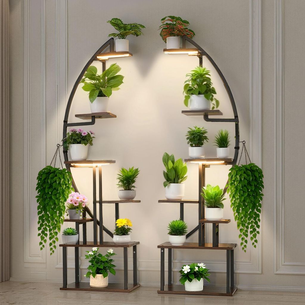 A plant stand with multiple shelves and plants, illuminated by built-in lights, placed against a wall.