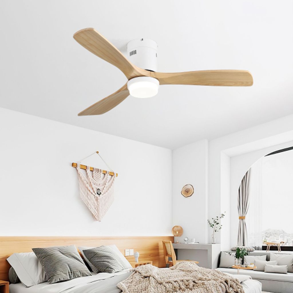 A modern bedroom with a white ceiling fan with wooden blades and an integrated LED light.