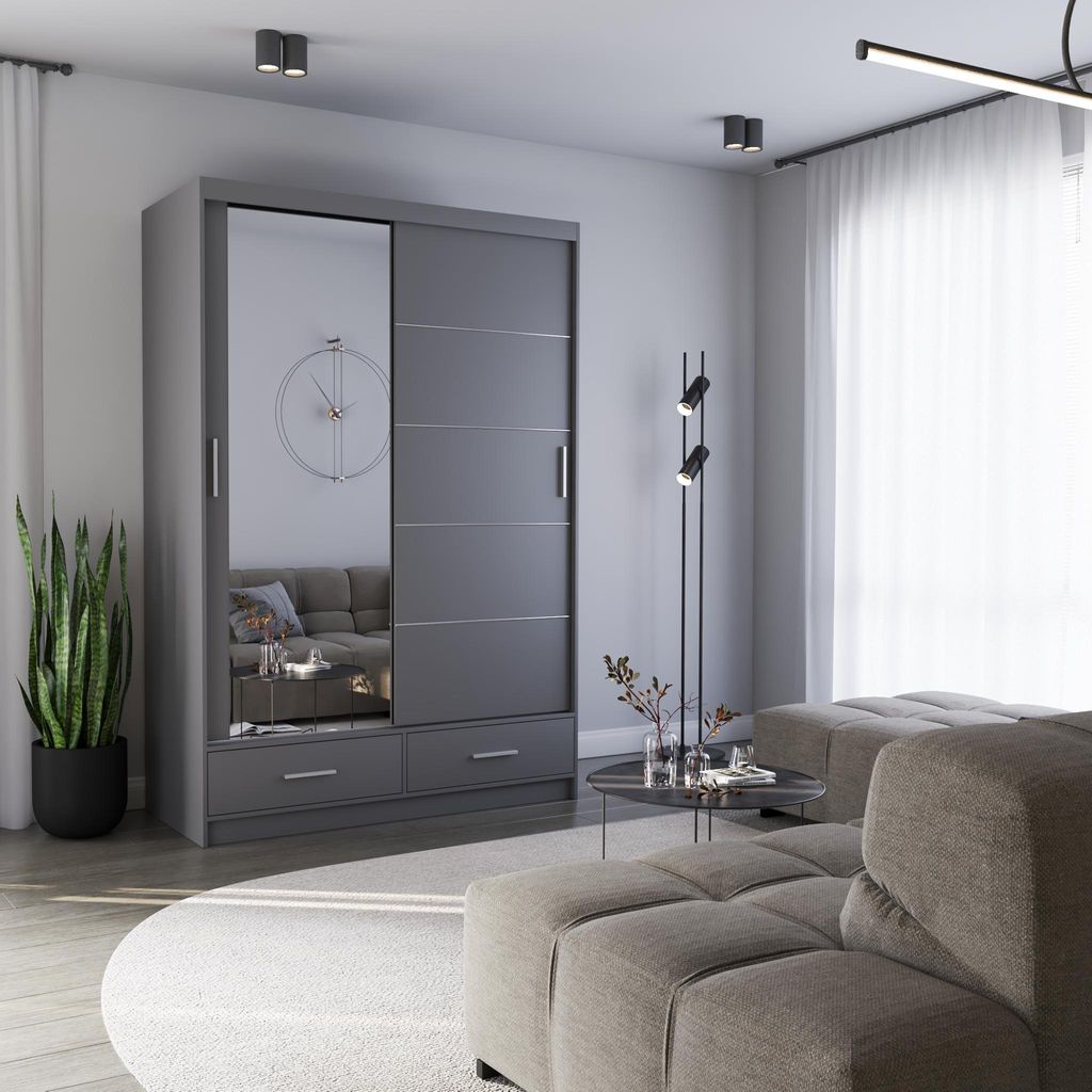 A modern bedroom or living room setting featuring a gray sliding door wardrobe with a mirrored panel, a sofa, a coffee table, and a floor lamp.