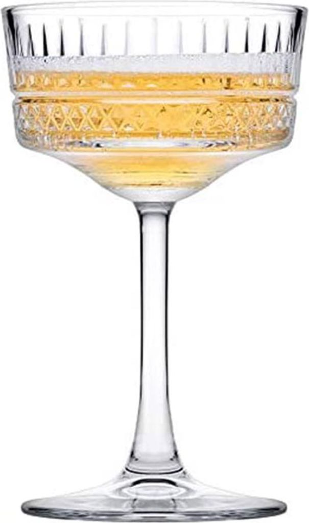 A single champagne coupe glass filled with a golden beverage, presented on a white background.