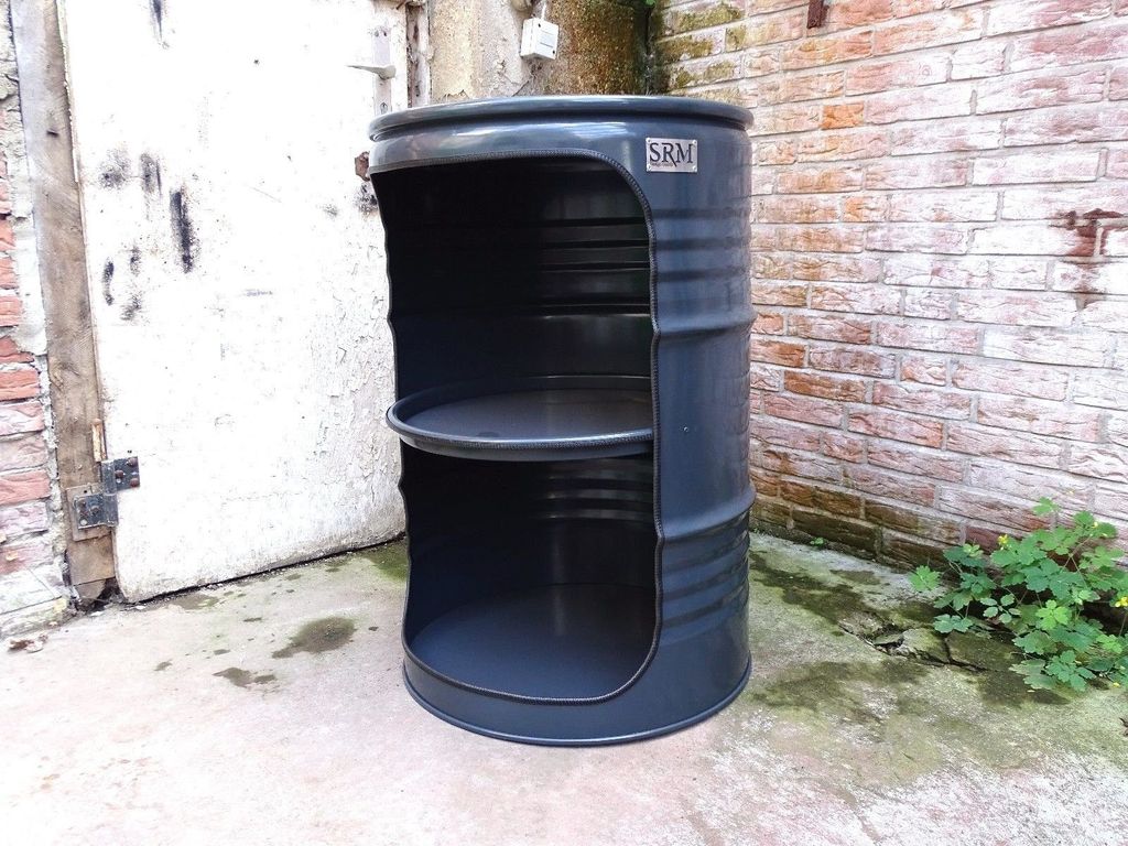 A modified oil barrel used as a shelf unit, placed outdoors next to a brick wall and a white door.