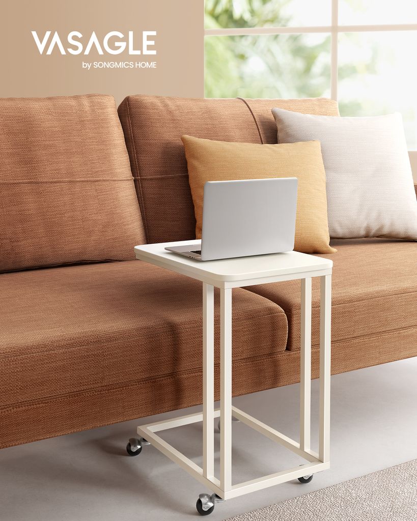 A small C-shaped table with a laptop on it, placed next to a brown sofa with pillows.