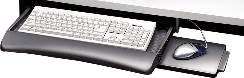 A keyboard tray with a keyboard and mouse pulled out from under a desk.