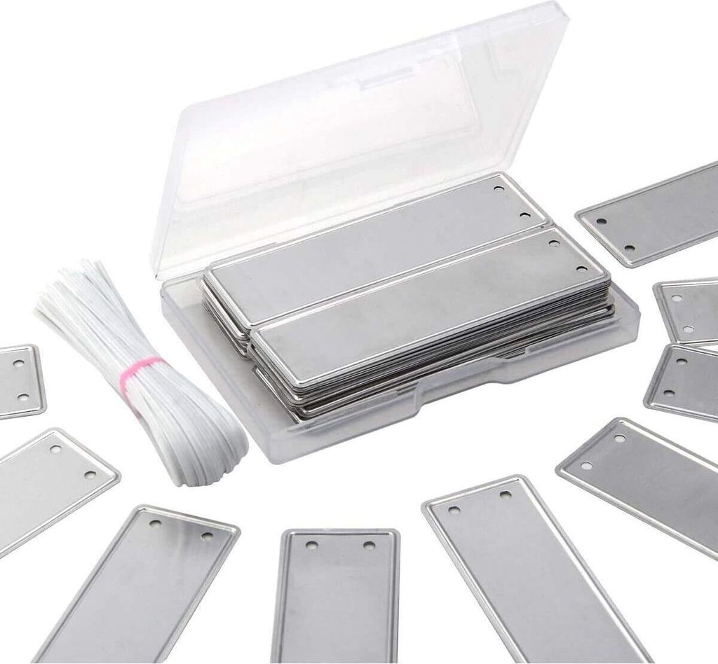 A collection of metal plant labels and a bundle of white ties, neatly arranged on a white background.
