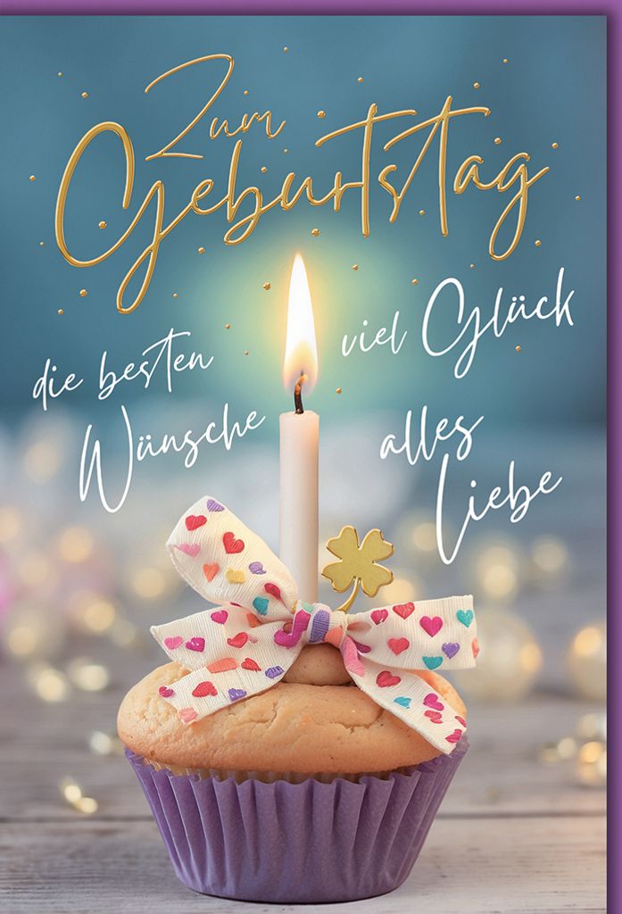 A birthday cupcake with a lit candle, a bow, and a clover charm, set against a soft blue background with bokeh lights.
