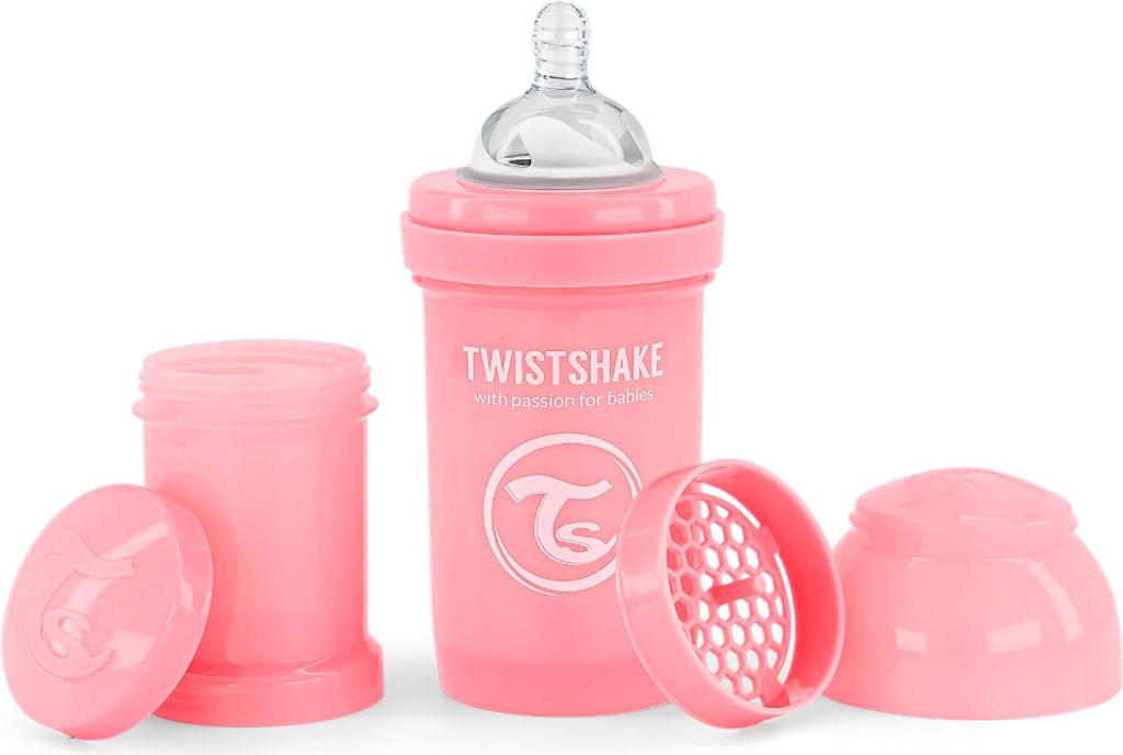 A pink baby bottle with its accessories laid out on a white background.