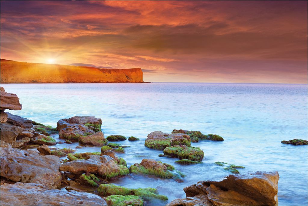 Wallario Premium Vliestapete Fototapete Sonnenaufgang am Meer mit Landzunge und Felsen im Wasser in der Größe 400 x 267 cm, extra dick, wird in 5...