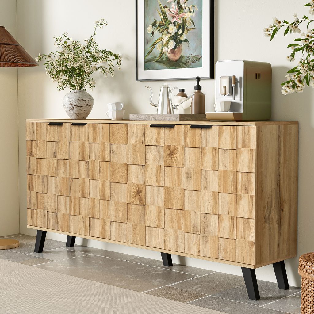 A wooden sideboard with a textured front is shown in a room setting, decorated with a vase of flowers, a coffee maker, and a framed picture.