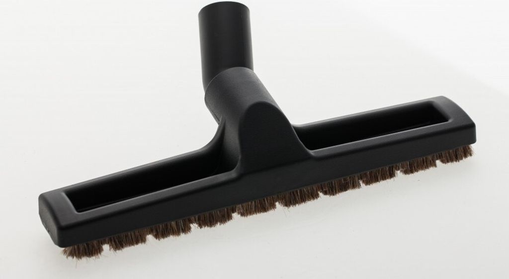 A black vacuum cleaner attachment with brown bristles is placed on a white background.
