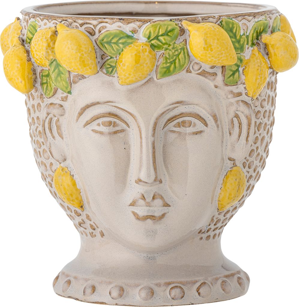 A close-up studio shot of a ceramic planter shaped like a face adorned with lemons and leaves.