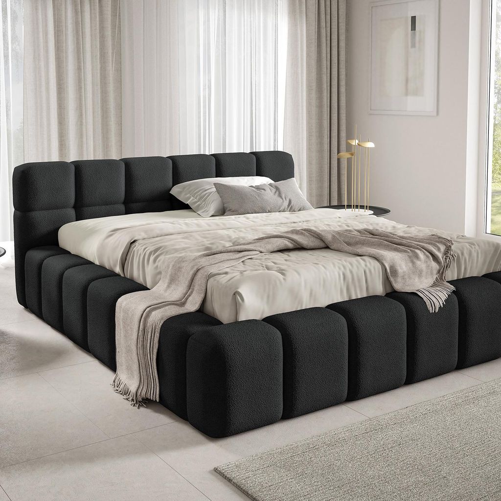 A modern bedroom with a large, upholstered bed.