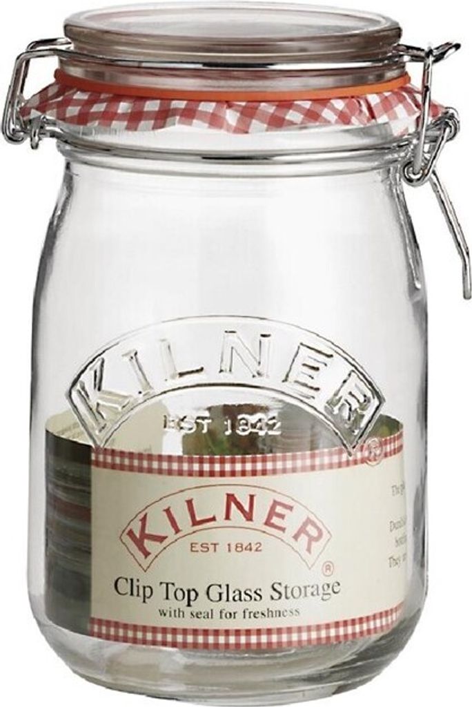 A clear studio shot of a Kilner glass storage jar with a clip-top lid and a red and white gingham seal.