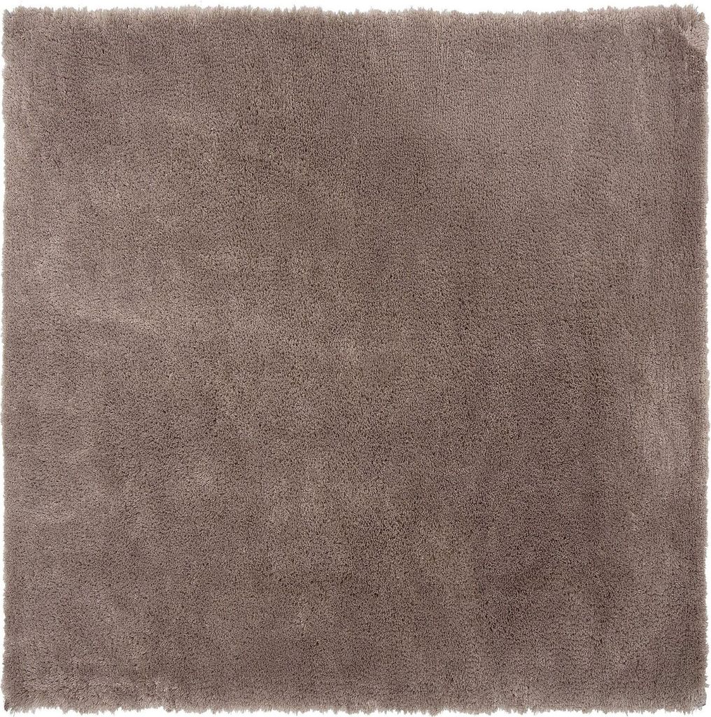 A close-up, top-down view of a square, shaggy rug in a light brown color.