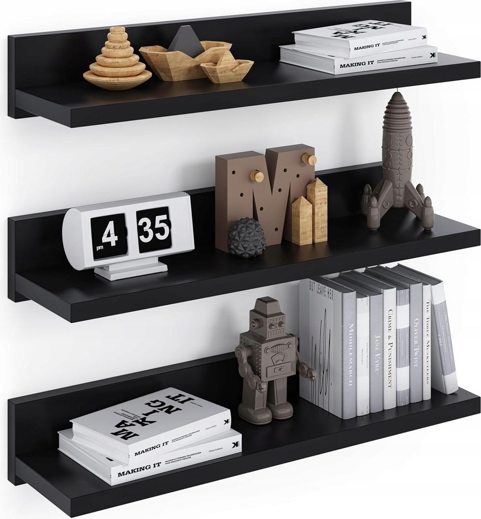 Three black floating shelves mounted on a white wall, decorated with various items.