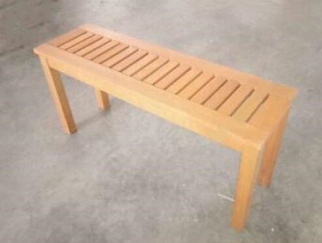 A wooden bench on a concrete floor.