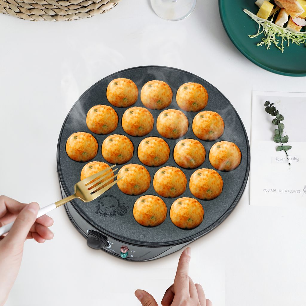 A takoyaki maker with 18 balls being cooked, with a fork in the foreground.