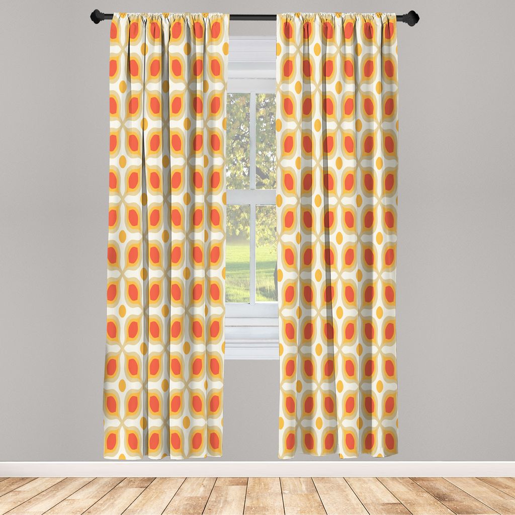 Two curtains with a geometric pattern hang in front of a window.