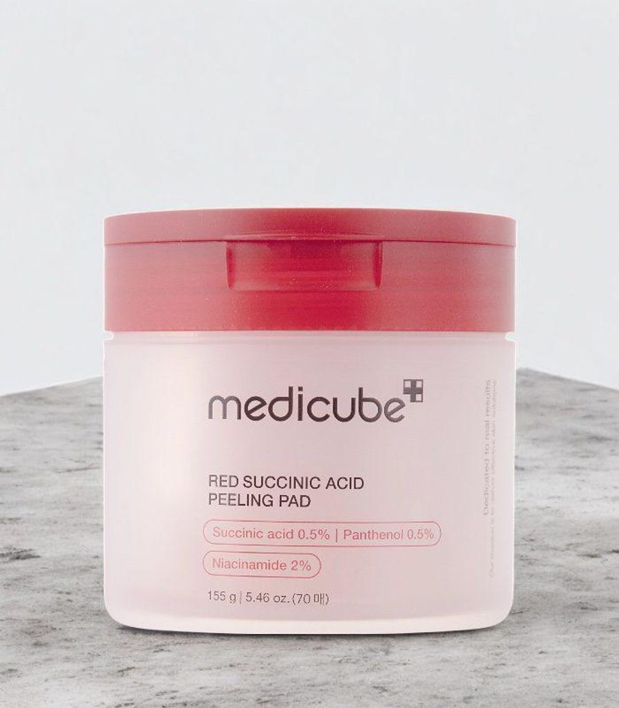 A product shot of a skincare jar on a textured surface.