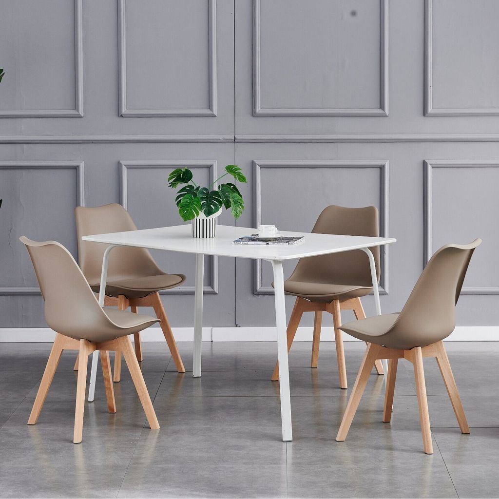 A dining set with a square table and four chairs in a room with gray paneled walls.
