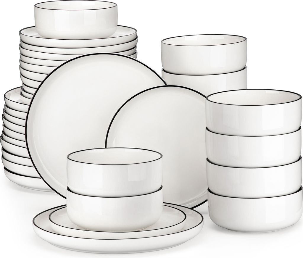 A collection of white ceramic plates and bowls with black trim, neatly stacked and arranged.